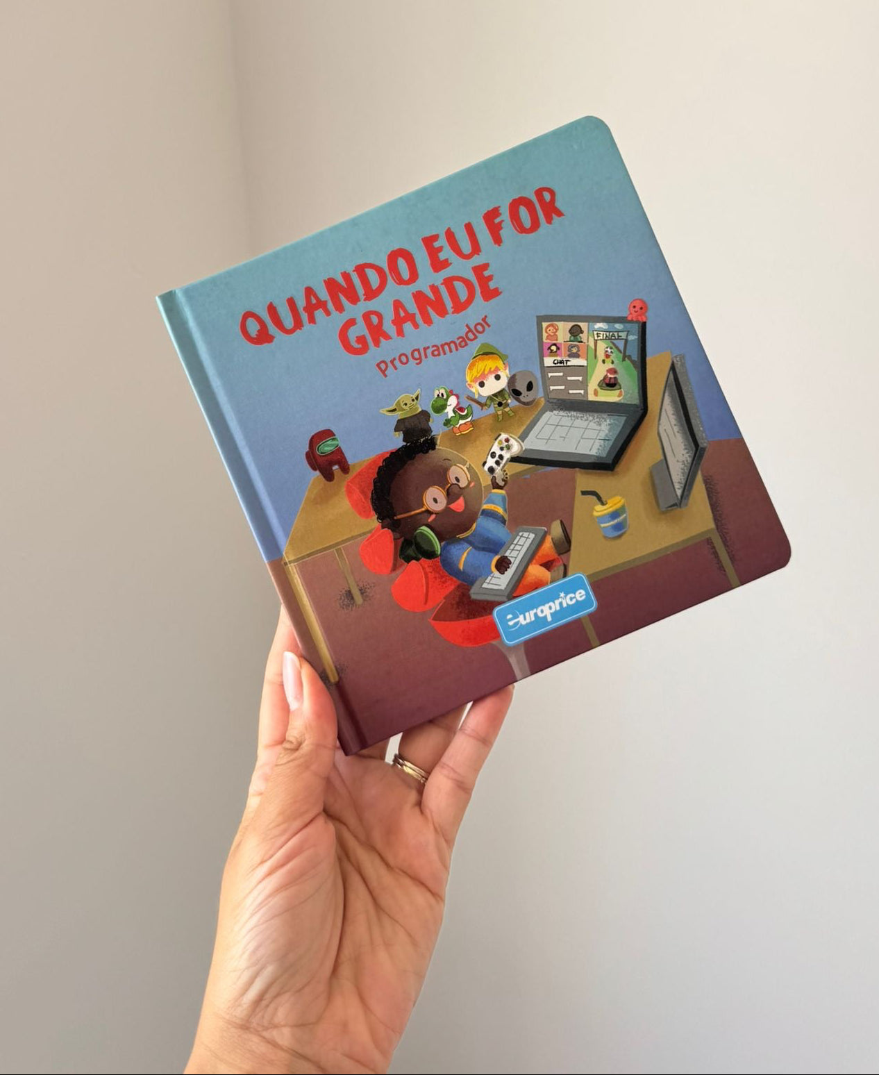 Children's book titled 'Quando Eu For Grande' held in a hand against a plain background